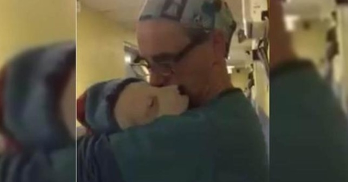 Tierarzt wiegt verängstigten und weinenden Rettungswelpen nach einer Operation wie ein Baby